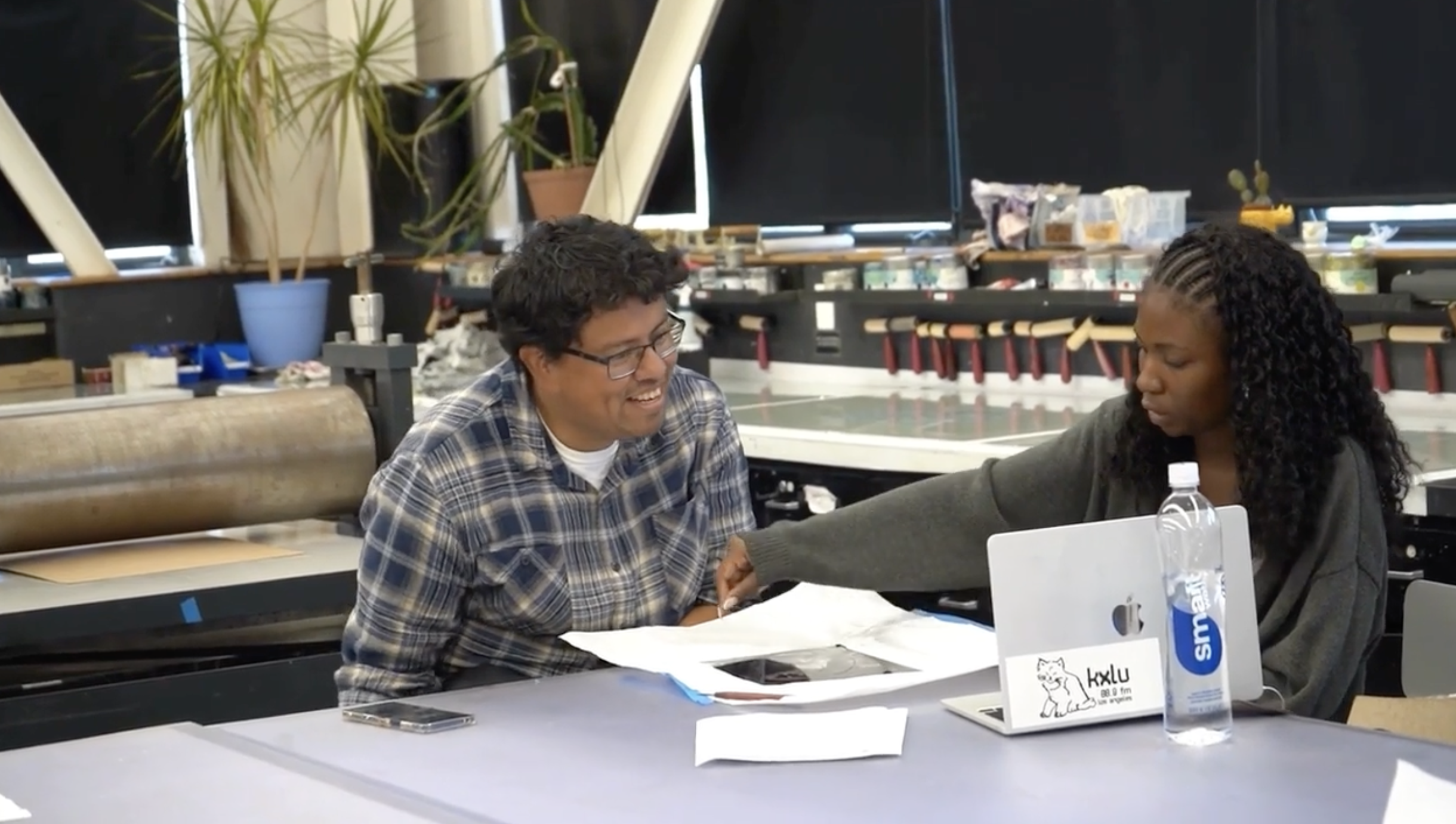 Professor teaching printmaking to student